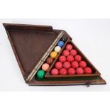 Early 20th century set of snooker balls in fitted mahogany triangular box housing composite balls