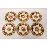 Set of six Royal Worcester plates with hand-painted fruit reserves within a gilt and puce border,