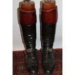 Pair of gentlemen's black leather hunting boots with brown tops and wooden trees and a pair of