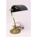 Contemporary brass desk lamp with swivel green shade, on a circular base,