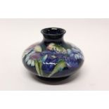 Moorcroft pottery squat vase with floral decoration on blue ground - impressed marks to base,