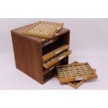 Eight-drawer wooden cabinet containing brass letters and numbers for use in book binding