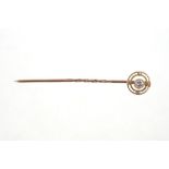 Edwardian diamond stick pin with a central brilliant cut diamond within concentric gold circles