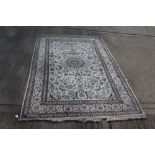 Large Eastern rug with central petalled medallion and meandering lotus flowers against cream ground,