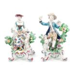 Pair 18th century Bow polychrome figures with dogs and bocage, on rococo scroll feet,