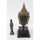 Antique Chinese bronze Buddha head with traces of gilded decoration, on ebonised display stand,