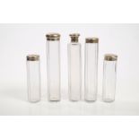 Four Victorian decagonal glass toilet bottles with silver engine-turned and monogrammed tops