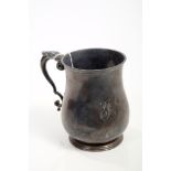 Late Edwardian silver mug of baluster form, with leaf mounted scroll handle and engraved initials,