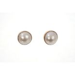 Pair cultured Mabe pearl ear studs in yellow metal setting,