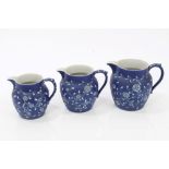 Set of three late Victorian Wedgwood blue Jasper ware graduated jugs with unusual white slipware