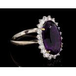 Amethyst and diamond cluster cocktail ring with an oval mixed cut amethyst surrounded by a border