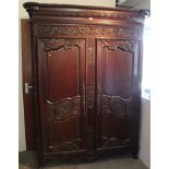 19th century French style carved walnut armoire enclosed by pair of panelled cupboard doors,