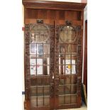 Late 19th / early 20th century carved oak bookcase enclosed by pair of Mackintosh-style leaded