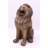 Eastern carved and polychrome painted model of a lion, seated, face fixed in a roar,