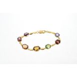 Gold and multi-gem set bracelet with a line of semi-precious gemstones in gold setting,