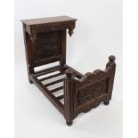 Early 20th century miniature carved oak half tester bed with floral relief carved head and foot