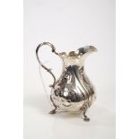 Victorian silver cream jug of baluster form, with embossed floral decoration and scroll handle,