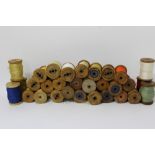 A box containing a quantity of vintage silk and silk floss thread on wooden spools - names