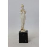 Fine 1920s German carved ivory figure of an elegant standing girl holding a garland of flowers,