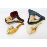 Collection of four carved 'face mask' meerschaum pipes - two with fitted cases and a separate