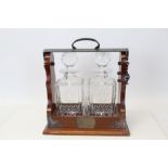 Contemporary mahogany two-bottle locking tantalus with silver plated fittings and two cut glass