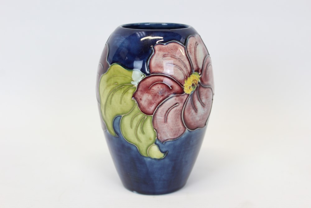 Moorcroft pottery vase decorated in the Hibiscus pattern on blue ground,