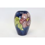 Moorcroft pottery vase decorated in the Hibiscus pattern on blue ground,