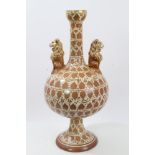 A Cantagalli pottery vase with cylindrical neck, two lion handles to the bulbous globe-shaped body,