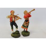 Pair of Scandinavian carved figures of a male and female musician, underside signed - 'Henning',