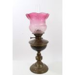 Edwardian brass oil lamp with acid-etched cranberry glass shade,