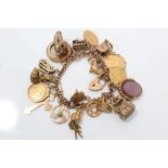 Gold (9ct) charm bracelet with a quantity of gold and yellow metal charms - including a Georgian