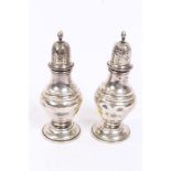 Pair Edwardian silver pepperettes of baluster form, with pierced slip-in covers,