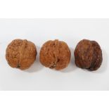 Three Japanese carved walnut shells, each allover relief carved with figures and foliage,
