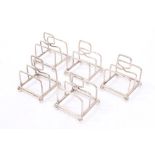 Five 1920s silver individual toast racks of tubular form, with loop handles,