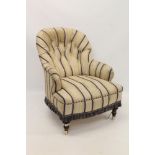 Victorian deep upholstered armchair, striped button upholstery, on turned legs and castors,