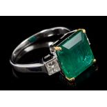 Emerald and diamond three-stone ring with a rectangular step cut emerald estimated to weigh