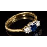 Sapphire and diamond three-stone ring with a central oval mixed cut blue sapphire measuring