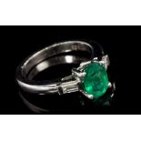 Emerald and diamond three-stone ring with an oval mixed cut emerald measuring approximately 8.