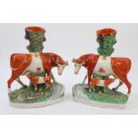Pair Victorian Staffordshire cow and calf spill vases with orange and gilt decoration, 29.