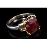 Ruby and diamond three-stone ring with a rectangular step cut ruby estimated to weigh approximately