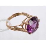 Gold and faux alexandrite single stone dress ring in four-claw setting with gold wirework shoulders.