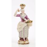 19th century Meissen porcelain figure of a lady fruit seller with basket of fruit on her head and