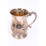 Large 19th century white metal mug of baluster form, with embossed foliate decoration,