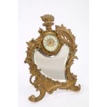 Late 19th century French gilt metal 'strut' clock with rococo scroll and bevelled mirrored panel,