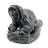 Inuit stone carving depicting an Eskimo wrestling with a walrus, inscribed - E.