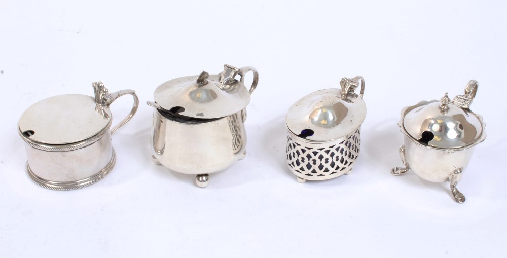 Four early 20th century silver mustard pots with blue glass liners, three hallmarked - Chester,