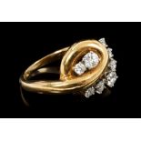Diamond dress ring with a polished yellow gold swirl,