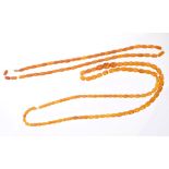 Two strings of graduated amber beads, length approximately 86cm and 60cm.