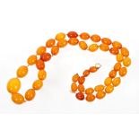 Old amber necklace with a long string of forty-four graduated oval butterscotch amber beads,