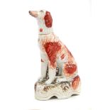 Unusual Victorian seated dog ornament with red sponged decoration, on naturalistic base, 27.